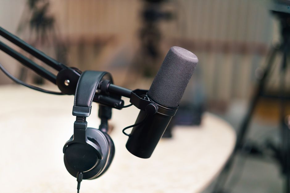 Close-up of a microphone and headphones setup in a professional recording studio.